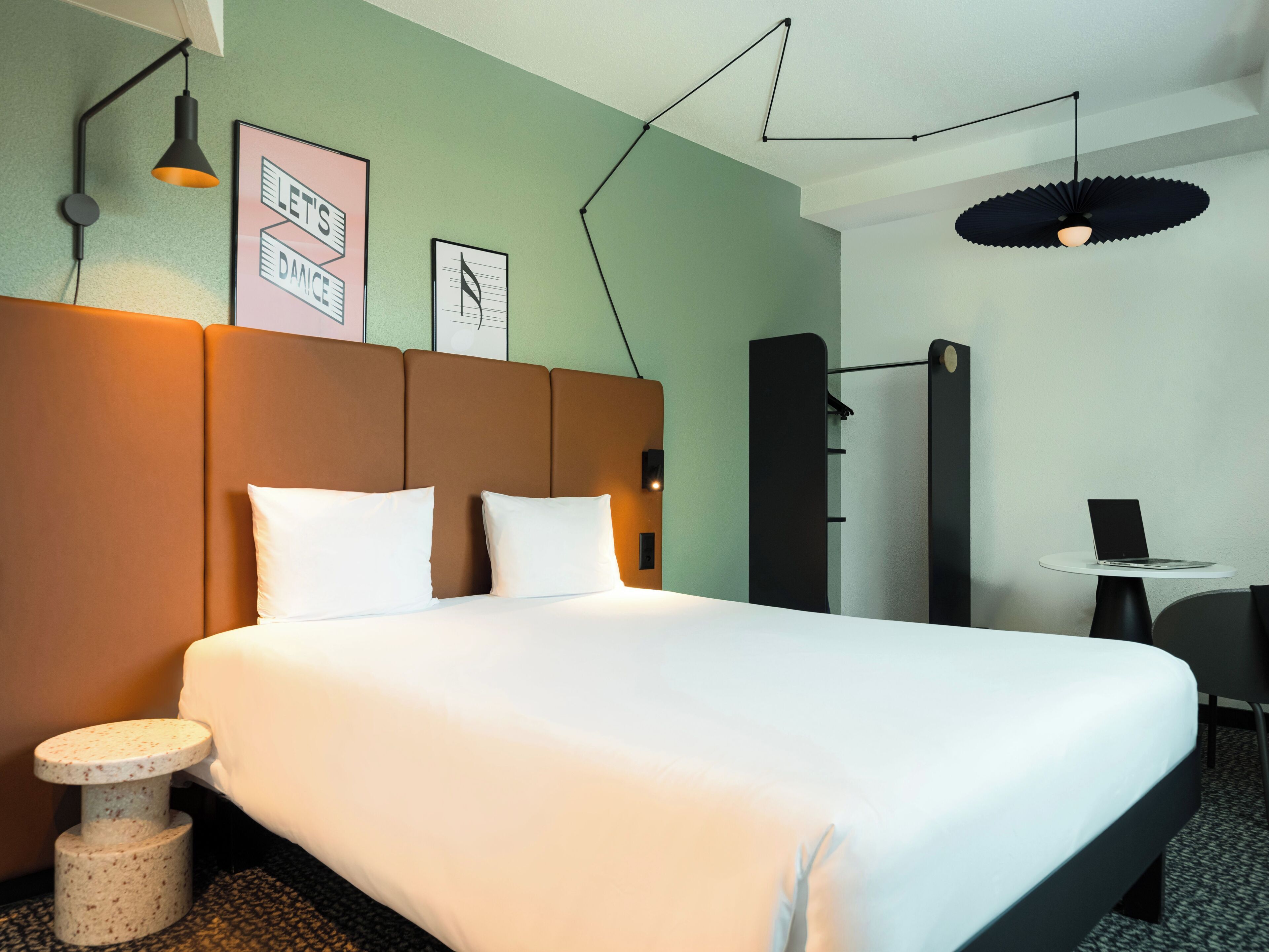 Une chambre d’hôtel avec un lit, un bureau, une chaise et une table ronde.
