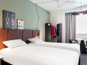 Una habitación de hotel con una cama grande, un escritorio y un armario.