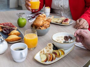 Une table dressée pour le petit-déjeuner, avec divers aliments et boissons.