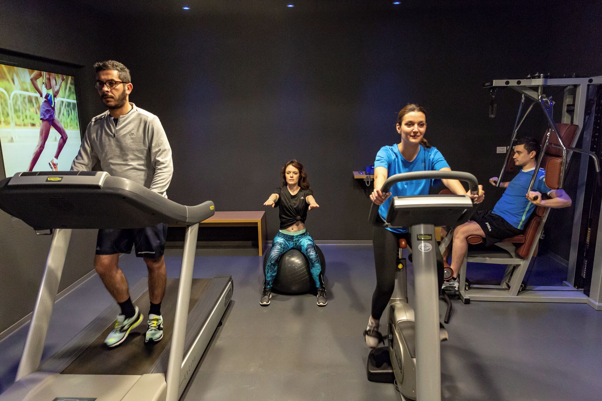 A gym with treadmills, a stationary bike, and a rowing machine.