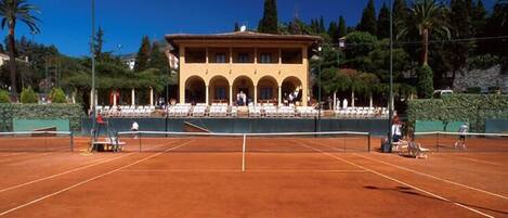 Una cancha de tenis con un edificio al fondo.