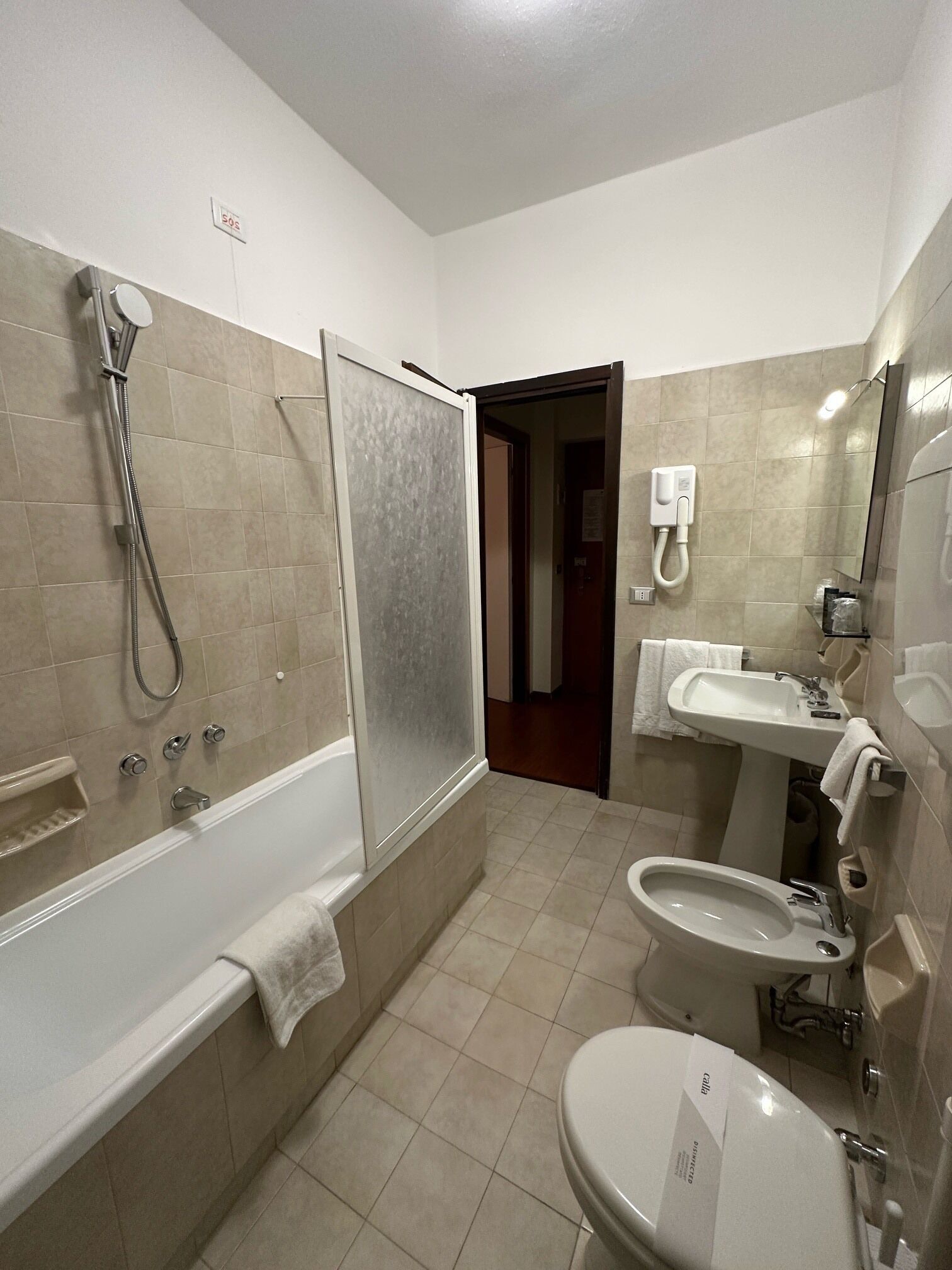Een badkamer met een bad, een douche, een wastafel en een toilet met douchefunctie.