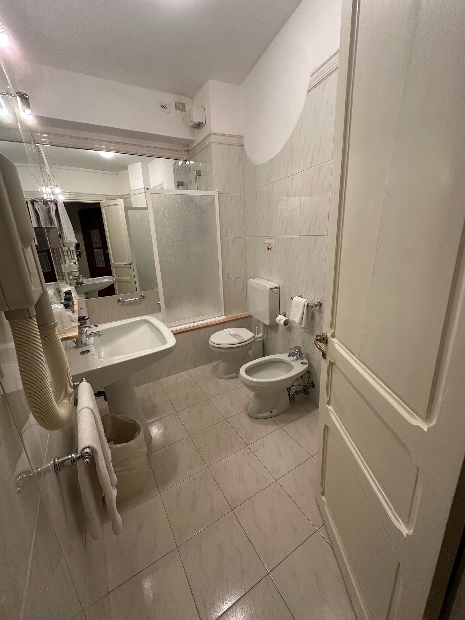 Een moderne badkamer met een wastafel, toilet, douchetoilet en spiegel.