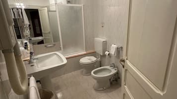 Une salle de bain moderne équipée d’un lavabo, de toilettes, d’un bidet et d’un miroir.
