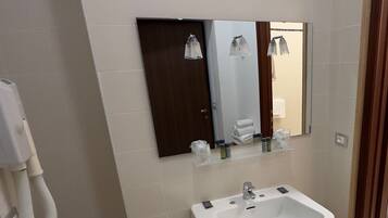 A bathroom with a sink, mirror, and toilet.