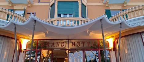 A hotel facade with balconies and a sign that reads 'LONDRA GRAND HOTEL'.