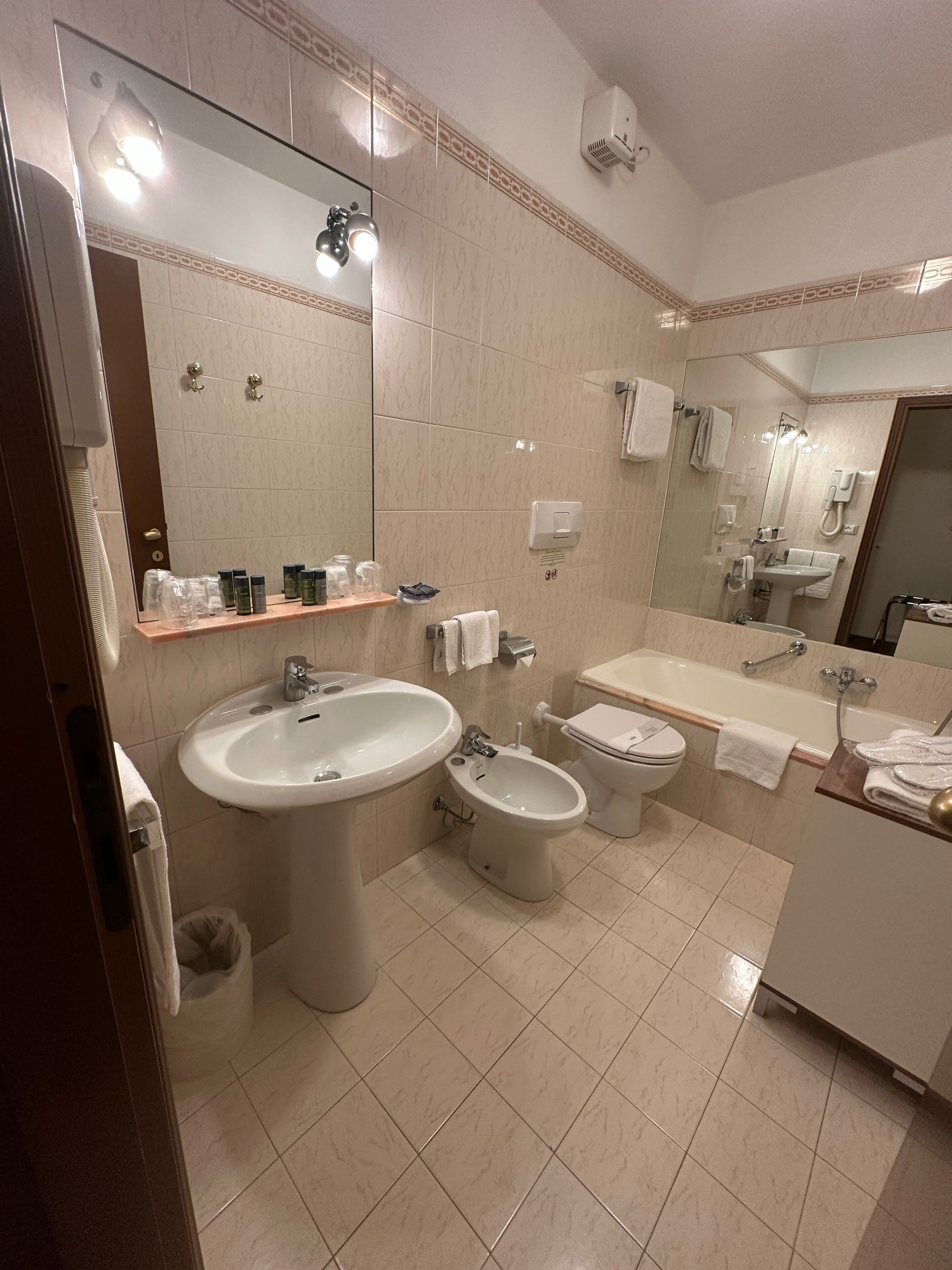 Un baño moderno con un lavamanos grande, un bidé, un inodoro y un espejo.