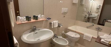 Un baño moderno con un lavamanos grande, un bidé, un inodoro y un espejo.