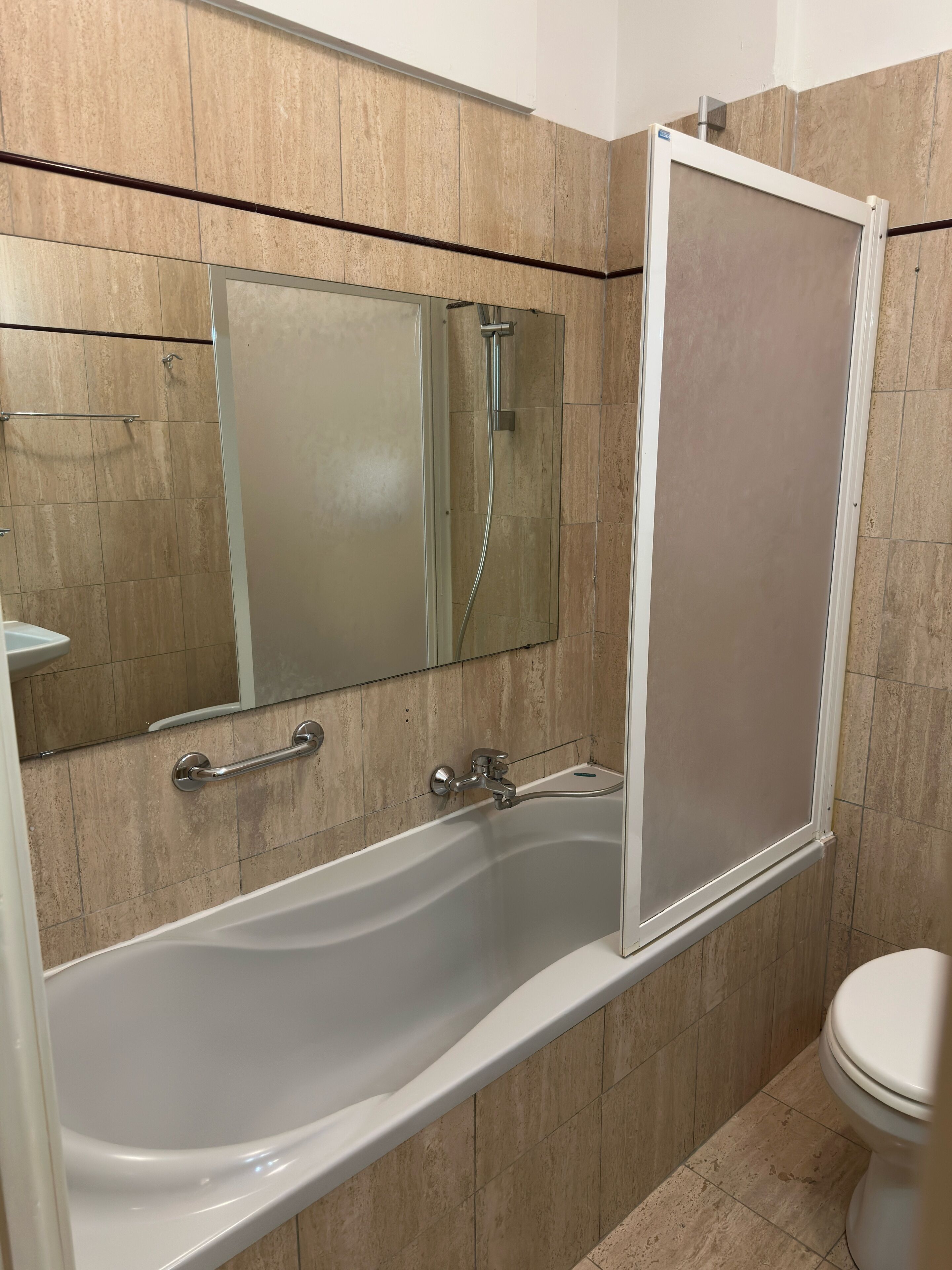 Un baño con bañera, cabina de ducha, inodoro y espejo.