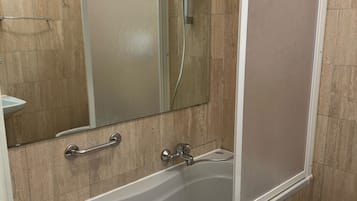Un bagno con vasca, cabina doccia, WC e specchio.