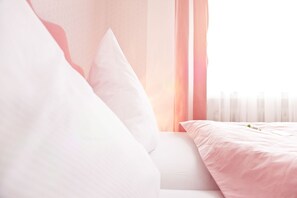 Ropa de cama hipoalergénica y caja de seguridad en la habitación