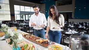 A buffet setup with various food items and a large pot on the table. - Epic Hotel San Luis (La Punta)
