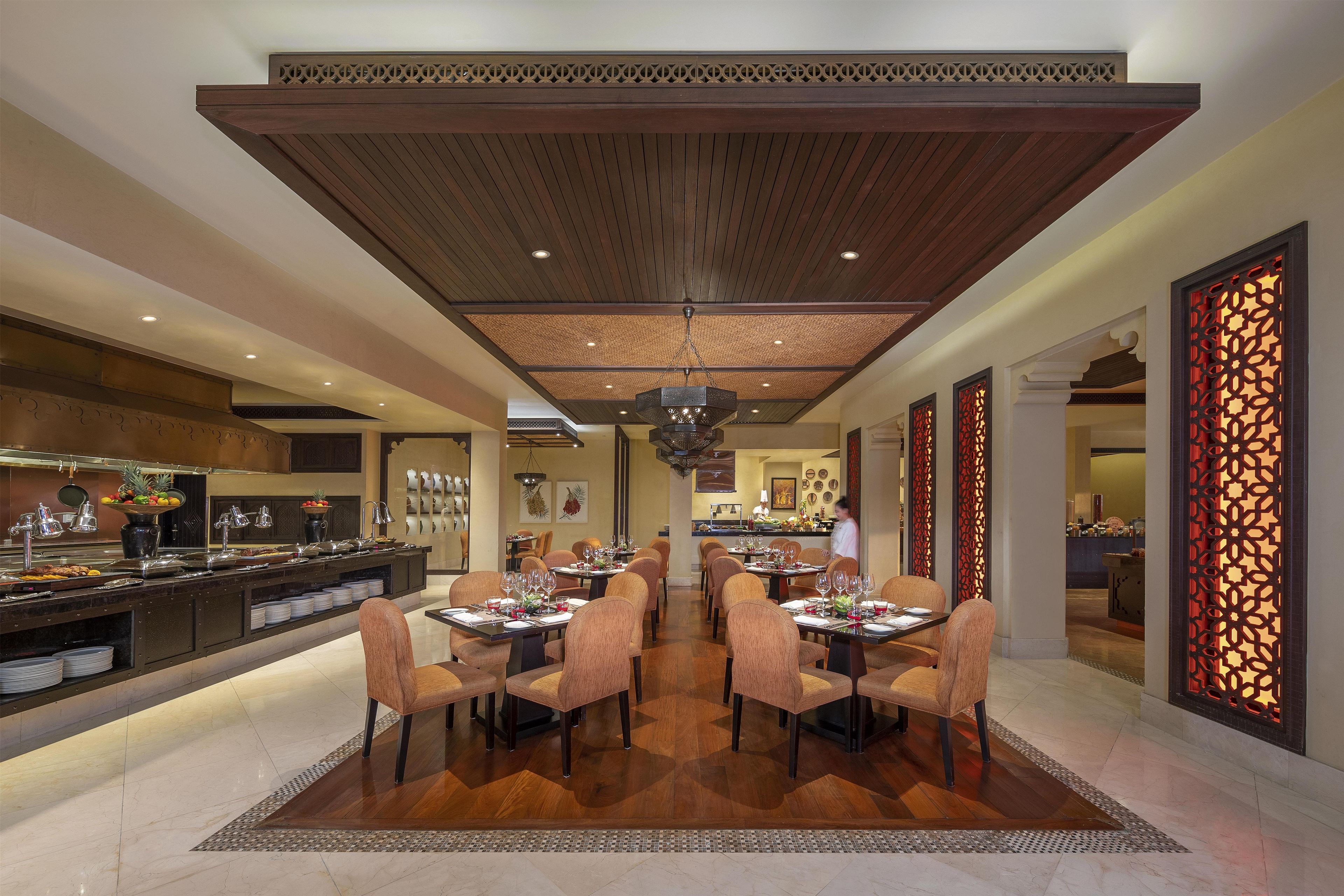 A spacious dining area with a high ceiling, a central chandelier, and a buffet on one side.