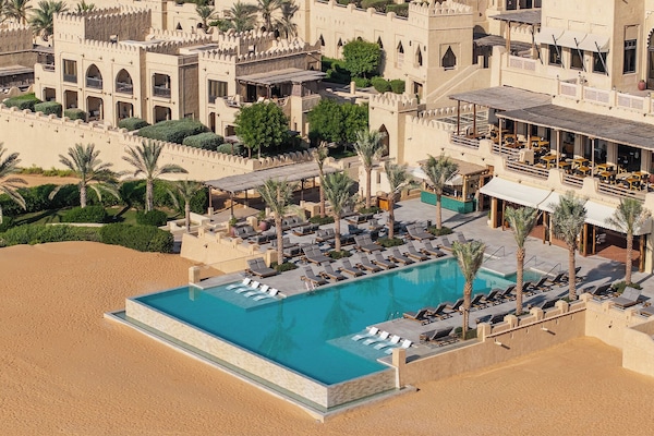 Een buitenzwembad, parasols voor strand/zwembad