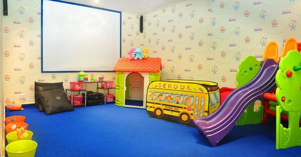 A playroom with a school bus, a slide, and a small house. - Hard Rock Hotel Penang (George Town)