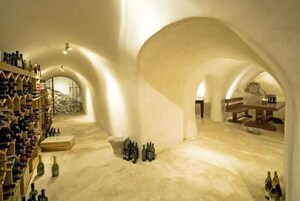 Una bodega con techos abovedados y estanterías de madera para vino.