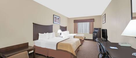 A hotel room with two beds, a desk with a computer, a chair, and a TV.