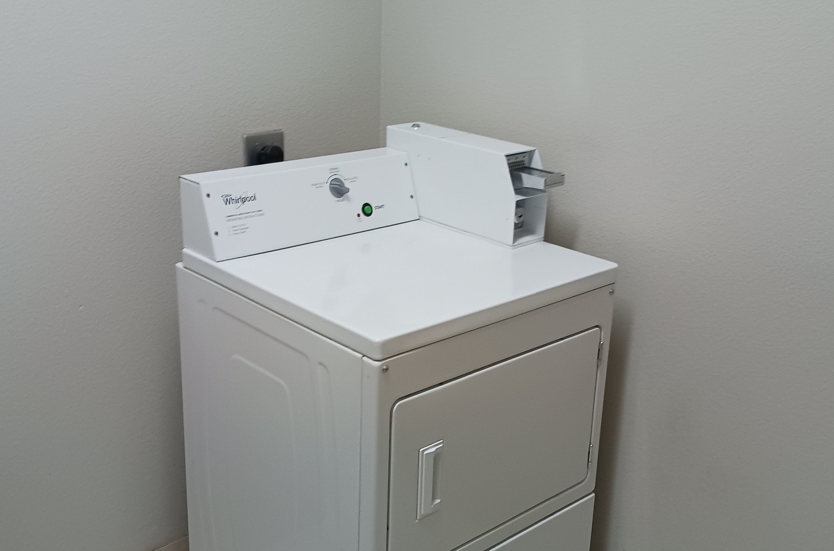A compact, white, wall-mounted washer and dryer unit with a control panel and a start button.