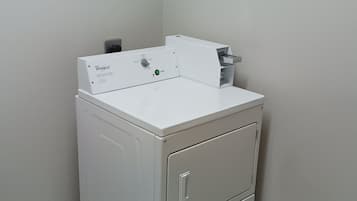 Lavadora y secadora empotradas, de color blanco y tamaño compacto, con panel de control y botón de inicio.