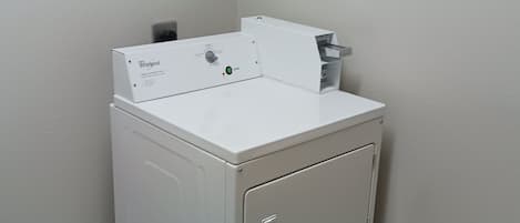 Lavadora y secadora empotradas, de color blanco y tamaño compacto, con panel de control y botón de inicio.