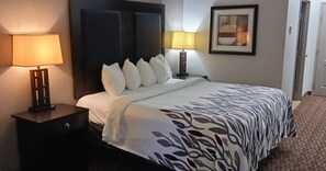 A hotel room with a bed, two bedside lamps, a nightstand, a drawer, and a framed picture on the wall. - Red Roof Inn & Suites Longview (Longview)