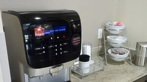 Eine Folgers Kaffeemaschine mit digitaler Anzeige, einer Kaffeeausgabe und einem Wasserzulauf.