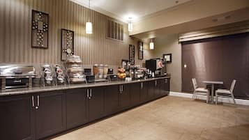 Een hotelkeuken met een buffetopstelling, inclusief een zelfbedieningsstation met diverse etenswaren en een koffieapparaat.