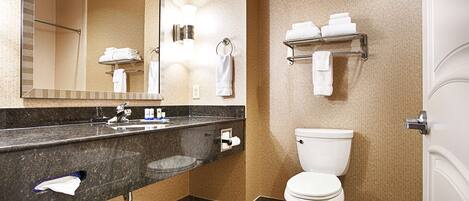 Une salle de bain moderne avec un comptoir en granit, des toilettes blanches, un porte-serviettes et un miroir.