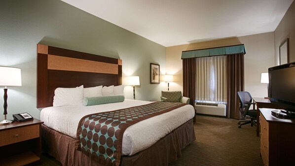 A hotel room with a large bed, bedside lamps, a desk with a television, and a chair. - Best Western Plus Texarkana Inn & Suites (Texarkana)
