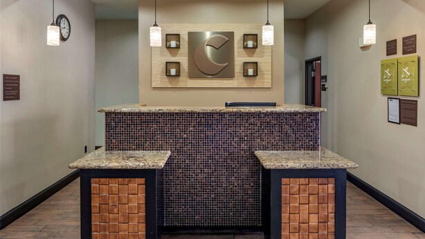 A reception area with a clock, a large crescent moon decoration, and a tiled counter. - Comfort Inn & Suites Paris (Paris)