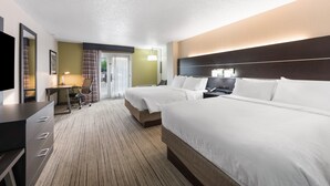 A hotel room with two beds, a desk, a chair, a TV, and a door leading to a balcony. - Holiday Inn Express Columbus Downtown by IHG (Columbus)