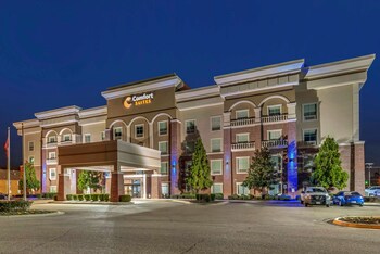 A modern kitchen with a built-in grill, coffee station, and a counter with food display. at Comfort Suites West Memphis I-40 I-55