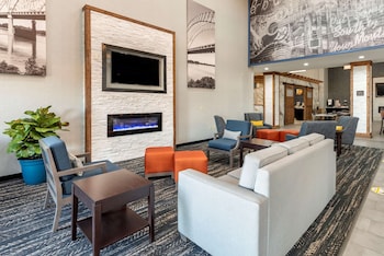 A reception desk with a geometric pattern and a modern design. There is a sign on the floor indicating social distancing measures. at Comfort Suites West Memphis I-40 I-55