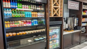 Un distributeur automatique de boissons proposant des options réfrigérées et surgelées, notamment des bières, des vins et des jus de fruits.