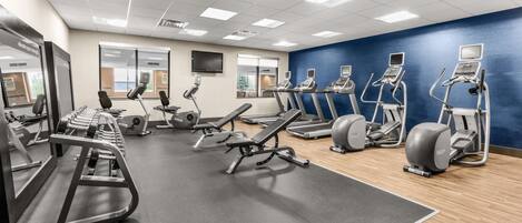 A gym with treadmills, elliptical machines, and weight equipment.