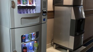 A vending machine with snacks and drinks, and a coffee machine. - Amber Inn Motel Le Mars (Le Mars)