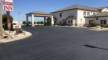 A Lee County Inn with a clear road leading to the entrance, a stop sign, and an exit sign.