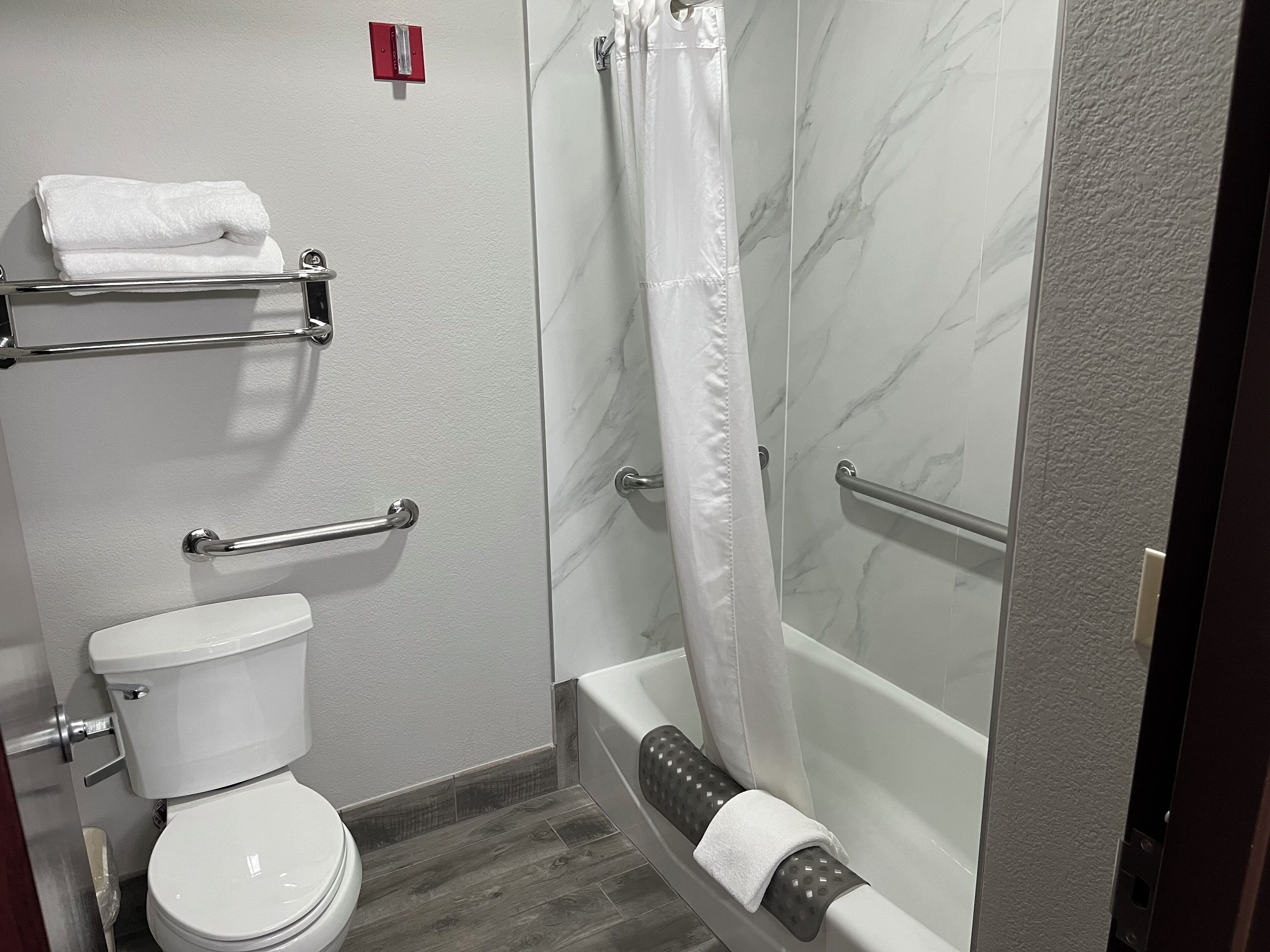 A bathroom with a toilet, a shower with a glass door, and a bathtub.