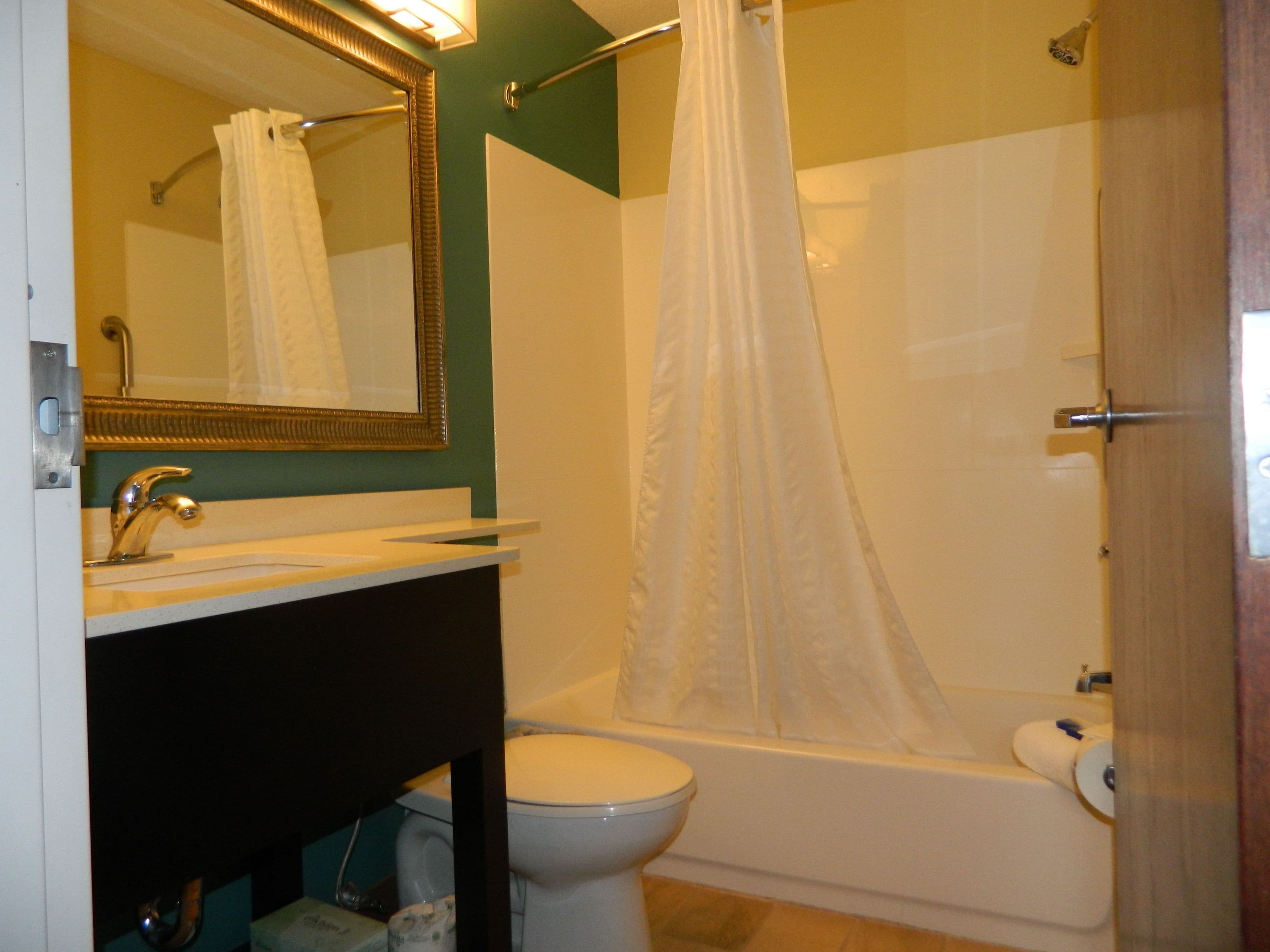 Een badkamer met toilet, wastafel en bad.