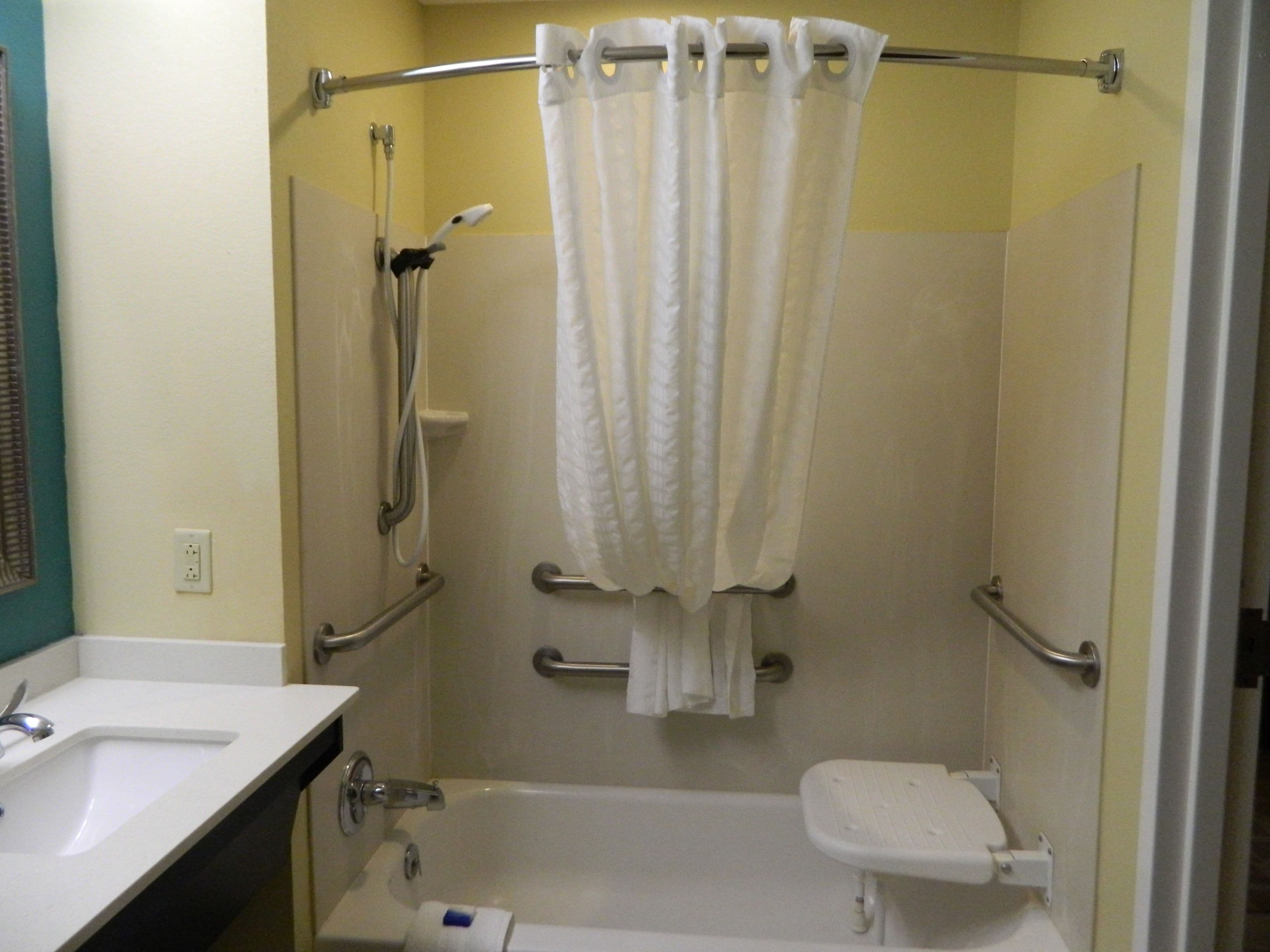 A bathroom with a bathtub, a toilet, and a shower area.