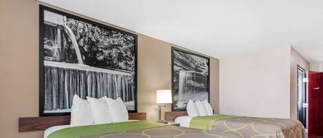 Habitación de hotel con dos camas, un ventanal grande y vista a una cascada.
