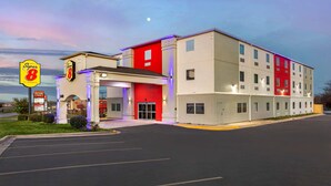 Ein Super 8 Hotel mit roter und weißer Fassade, mehreren Etagen und einem Parkplatz.
