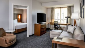 A hotel room with a bed, a TV, a desk with a chair, a sofa, and a small table. - Residence Inn by Marriott Birmingham Downtown at UAB (Birmingham)