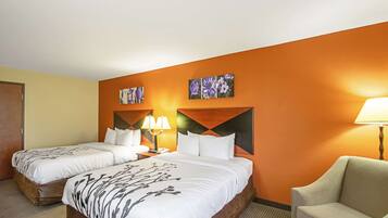A hotel room with two beds, a sofa, and artwork on the walls.