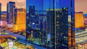 A high-rise hotel with a prominent "Grand Vacations" sign, surrounded by other buildings and a parking area.