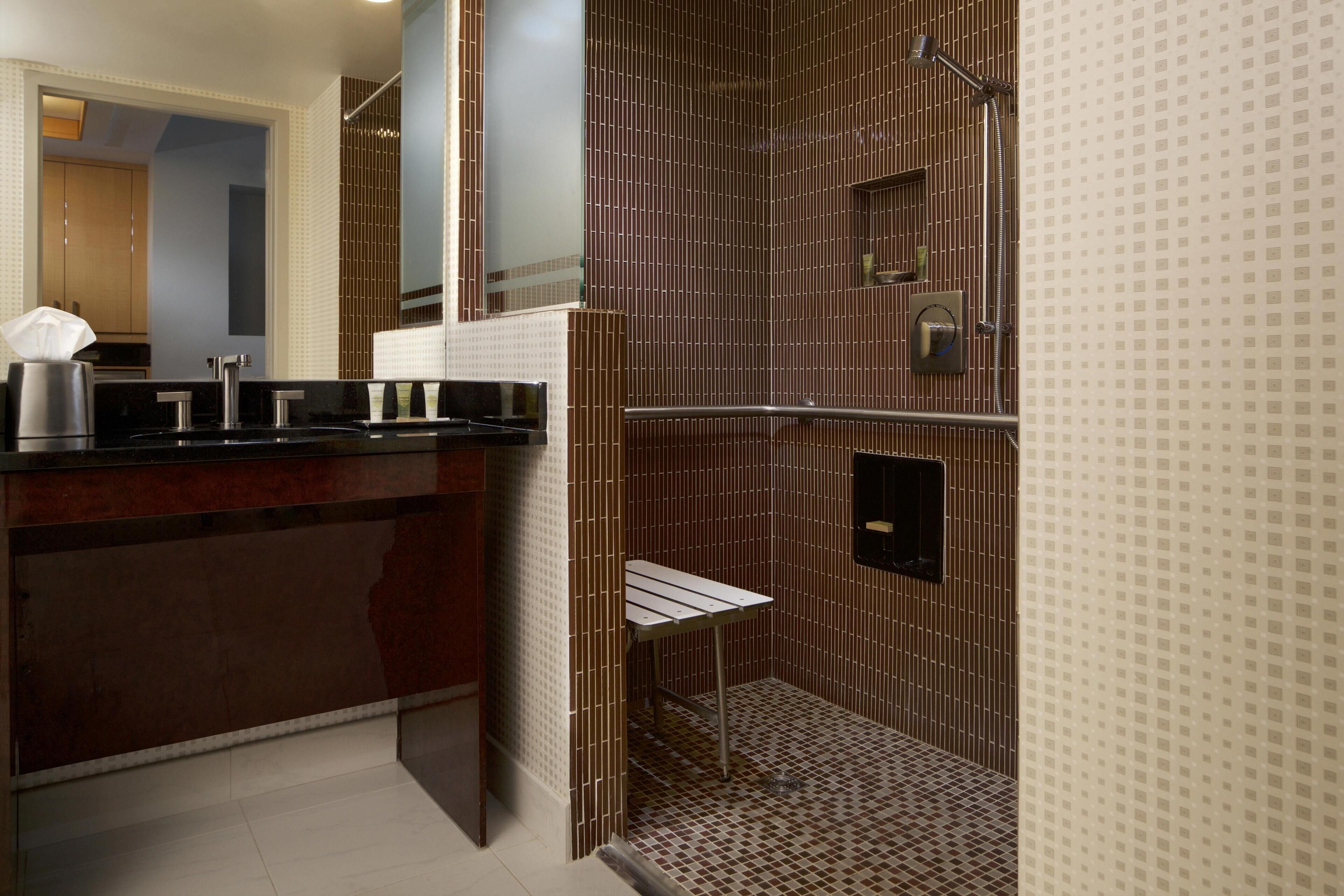 Ein modernes Badezimmer mit Dusche, Waschtisch mit Spiegel und Toilette.