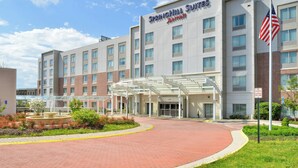 A SpringHill Suites Marriott hotel with a covered entrance, a fountain, and an American flag. - SpringHill Suites by Marriott Fairfax Fair Oaks (Fairfax)