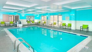 An indoor swimming pool with clear lanes, green chairs, and exit doors. - SpringHill Suites by Marriott Fairfax Fair Oaks (Fairfax)