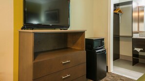 A hotel room with a television on a wooden stand, a microwave, and a refrigerator. - Quality Inn DeRidder (DeRidder)