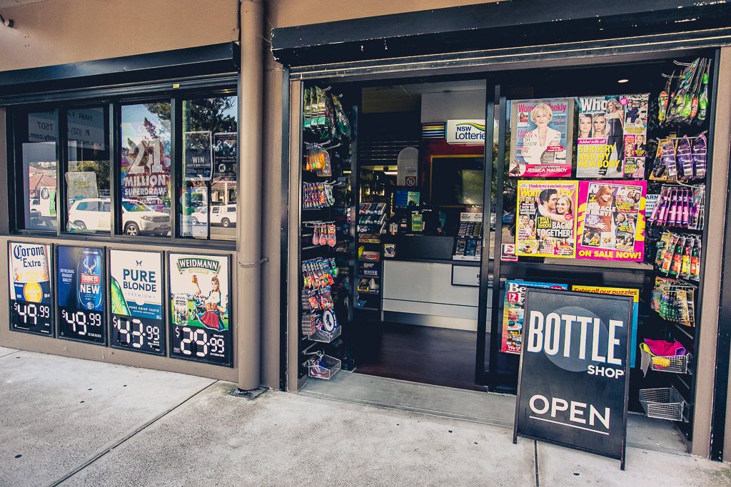 A store entrance with a sign indicating a bottle shop is open.